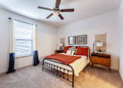 Thumbnail 14 of 32 - A bedroom with a bed, dresser, and window with curtains.