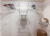 Thumbnail 13 of 32 - A white closet with shelves and hangers.