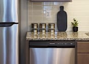 Thumbnail 18 of 27 - A kitchen with a stainless steel refrigerator and a black pot on the counter.