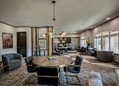 Thumbnail 12 of 29 - A modern living room with a large round table and comfortable seating.
