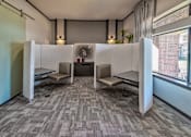 Thumbnail 17 of 29 - A room with grey carpet and two white booths with a fan in the middle.