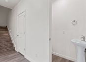 Thumbnail 4 of 24 - a bathroom with a sink and a door next to a staircase