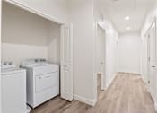 Thumbnail 5 of 24 - the living room and laundry room of a manufactured home with washer and dryer