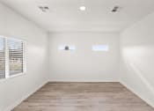 Thumbnail 7 of 24 - an empty room with white walls and wood floors and two windows
