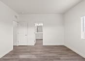 Thumbnail 9 of 24 - an empty bedroom with white walls and wood flooring