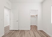 Thumbnail 13 of 24 - an empty bedroom with white walls and wood flooring
