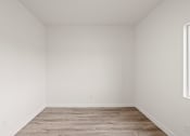 Thumbnail 15 of 24 - an empty room with wood floors and white walls