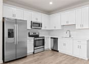 Thumbnail 2 of 24 - a white kitchen with stainless steel appliances and white cabinets