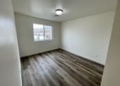Thumbnail 9 of 46 - an empty living room with wood flooring and a window