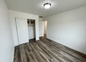 Thumbnail 22 of 46 - a long hallway with white walls and wood flooring