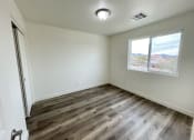 Thumbnail 28 of 46 - an empty living room with wood flooring and a window