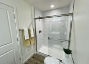 Thumbnail 11 of 46 - a small bathroom with a shower and a toilet