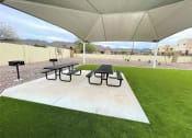 Thumbnail 16 of 46 - a picnic area with picnic tables under a tent