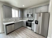 Thumbnail 39 of 46 - a kitchen with stainless steel appliances and gray cabinets