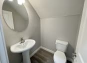 Thumbnail 44 of 46 - a small bathroom with a sink toilet and a mirror