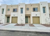 Thumbnail 25 of 46 - a building with three garage doors and a sidewalk