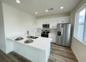Thumbnail 1 of 46 - a kitchen with a large island and a stainless steel refrigerator