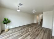 Thumbnail 7 of 46 - an empty living room with wood flooring and a potted plant