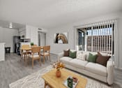 Thumbnail 1 of 39 - A living room with a white couch, a wooden coffee table, and a dining table with chairs.