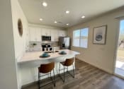Thumbnail 41 of 46 - a kitchen with a white counter top and a island with two chairs