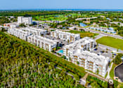 Thumbnail 56 of 59 - A large white building complex with a pool in the middle of it.