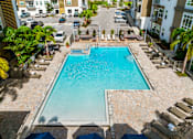 Thumbnail 58 of 59 - A swimming pool surrounded by lounge chairs and umbrellas.