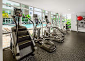 Thumbnail 7 of 59 - A gym with treadmills, elliptical machines, and a red ball.