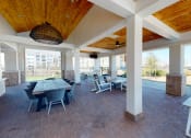 Thumbnail 23 of 33 - a covered patio with a wooden ceiling and brick flooring