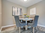Thumbnail 16 of 35 - A dining room with a table and chairs.