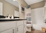 Thumbnail 26 of 35 - A bathroom with a toilet, sink, and shower.