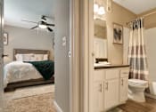 Thumbnail 25 of 35 - A bedroom with a bed, a toilet, and a shower.