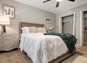 Thumbnail 23 of 35 - A bedroom with a white bed and a green throw blanket.