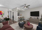 Thumbnail 2 of 30 - A living room with a red couch, a grey ottoman, and a television on the wall.