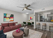 Thumbnail 1 of 30 - A living room with a red couch and a painting on the wall.
