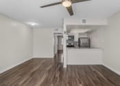 Thumbnail 11 of 30 - an empty living room and kitchen with a ceiling fan