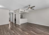 Thumbnail 14 of 30 - an empty living room with a ceiling fan and a kitchen