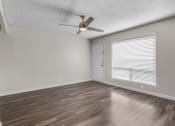 Thumbnail 22 of 30 - the spacious living room with a large window and a ceiling fan
