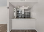 Thumbnail 13 of 30 - an empty kitchen with a counter top and a refrigerator and