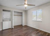 Thumbnail 19 of 30 - an empty living room with a ceiling fan and a laundry room
