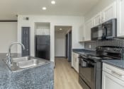 Thumbnail 18 of 29 - a kitchen with granite counter tops and black appliances
