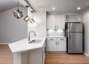 Thumbnail 26 of 33 - a kitchen with white cabinets and a white counter top