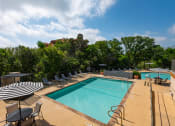 Thumbnail 12 of 33 - a resort style pool with lounge chairs and umbrellas