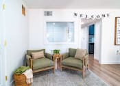 Thumbnail 32 of 44 - a living room with two chairs and a welcome sign on the wall