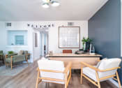 Thumbnail 30 of 44 - a living room with blue walls and a desk and chairs