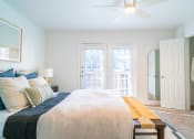 Thumbnail 15 of 44 - a bedroom with a bed and a closet and a ceiling fan
