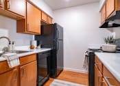Thumbnail 10 of 44 - a kitchen with wooden cabinets and a black refrigerator