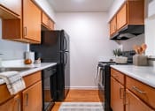 Thumbnail 9 of 44 - an empty kitchen with black appliances and wooden cabinets