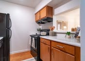 Thumbnail 11 of 44 - a kitchen with black appliances and wooden cabinets