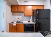 Thumbnail 12 of 44 - an empty kitchen with black appliances and wooden cabinets