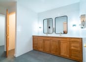 Thumbnail 18 of 44 - a bathroom with two mirrors and a wooden vanity